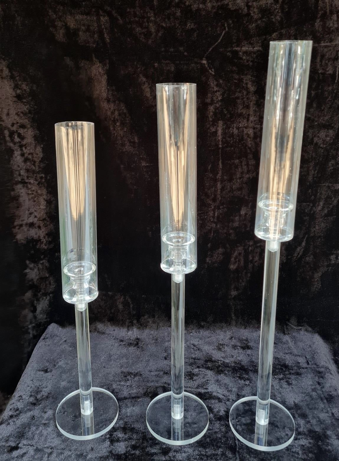 Set of three sleek clear stands designed for pillar candles